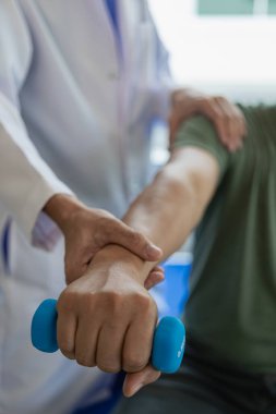 Doktor ya da fizyoterapist kol tedavisi, kas germe ve egzersizleri, ağrı terapisi, rehabilitasyon ve klinikte etkinliği belirlemek için çalışır. Yakın plan resimler.