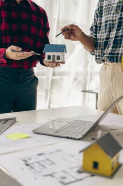 Mimar bulanık arka plan kağıt mimarisine odaklanıyor. Mimarlık, Asya endüstrisindeki profesyonel takım dikey resim şirketinde mühendislik konseptlerini sunmak için ofis planlarıyla çalışıyor.