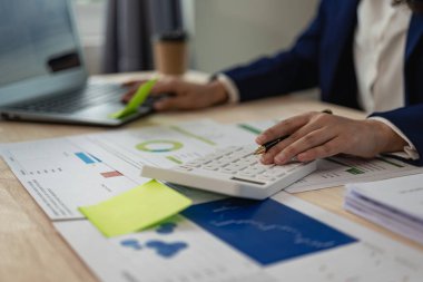 Ofiste çalışan denetçi ve muhasebeci mali verileri ve muhasebe kayıtlarını hesap makinesiyle analiz ediyor. Muhasebe şirketleri finansal ve vergi planlama hizmetleri sunar. Yakın plan resimler.