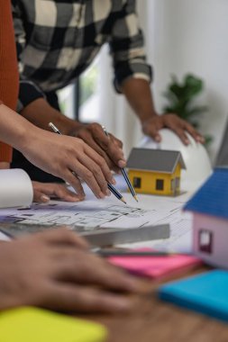 Mimar bulanık arka plan kağıt mimarisine odaklanıyor. Mimarlık, Asya endüstrisindeki profesyonel takım dikey resim şirketinde mühendislik konseptlerini sunmak için ofis planlarıyla çalışıyor.