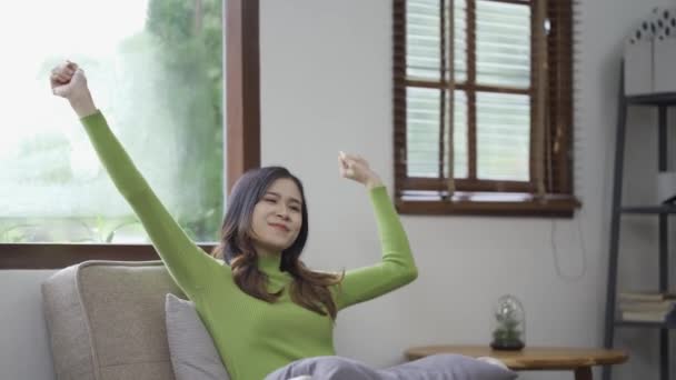 松懈的年轻亚洲女人在家里舒适的沙发上享受着放松 放松和呼吸室内空气 平衡和宁静的概念 — 图库视频影像