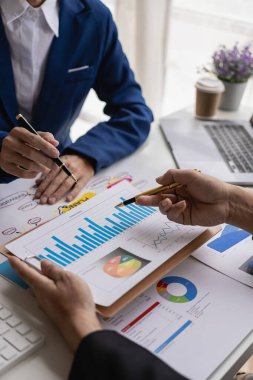 Bir dizüstü bilgisayar kullanarak dikey resimler, grafikler ve gelir grafikleri. İş analizi ve strateji kavramları bir iş danışmanıyla bir araya gelir ve finans ve yakın çekim fotoğraflarını tartışır