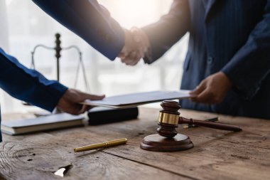 İş adamları erkek avukatlarla, hakimlerle, hukuk danışmanlarıyla anlaşma yapmak için el sıkışıyor. Bir dava planlamak için sözleşmeli danışmanlık hizmetleri. İş adamları ve avukatlar masada sözleşme belgelerini tartışıyor..