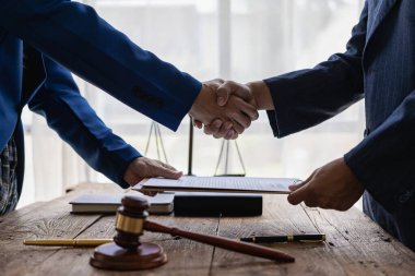 İş adamları erkek avukatlarla, hakimlerle, hukuk danışmanlarıyla anlaşma yapmak için el sıkışıyor. Bir dava planlamak için sözleşmeli danışmanlık hizmetleri. İş adamları ve avukatlar masada sözleşme belgelerini tartışıyor..