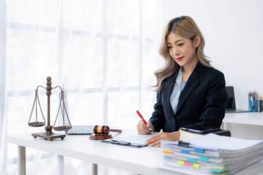 Ofiste ya da mahkemede çalışan genç bayan avukat Asya 'nın başarılı kadınının kontratını ve adalet terazisini çekiçle kontrol et. hukuki danışma kavramı