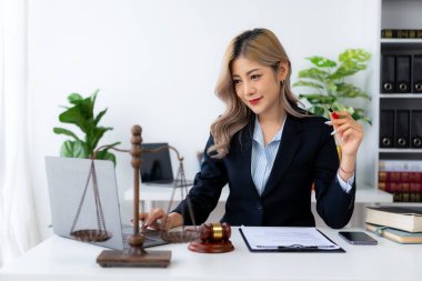 Ofiste ya da mahkemede çalışan genç bayan avukat Asya 'nın başarılı kadınının kontratını ve adalet terazisini çekiçle kontrol et. hukuki danışma kavramı