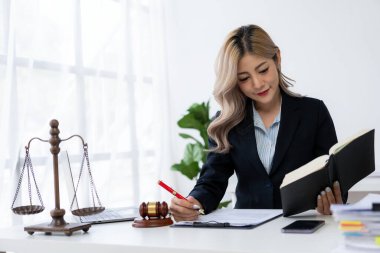 Ofiste ya da mahkemede çalışan genç bayan avukat Asya 'nın başarılı kadınının kontratını ve adalet terazisini çekiçle kontrol et. hukuki danışma kavramı