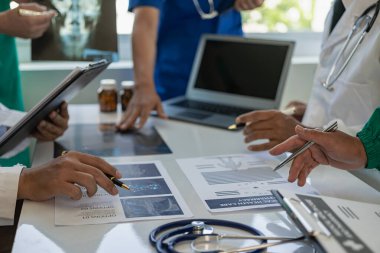 Beyaz önlüklü ve ameliyat önlüklü doktorla görüşüp hasta kayıtlarını tartışıyorlar. Dijital tablet üzerinde çalışan doktorlar, bilgisayar kullanan doktorlar tablet teknolojisi.