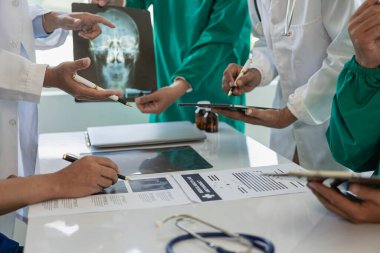 Beyaz önlüklü ve ameliyat önlüklü doktorla görüşüp hasta kayıtlarını tartışıyorlar. Dijital tablet üzerinde çalışan doktorlar, bilgisayar kullanan doktorlar tablet teknolojisi.