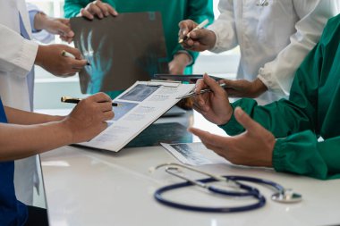 Beyaz önlüklü ve ameliyat önlüklü doktorla görüşüp hasta kayıtlarını tartışıyorlar. Dijital tablet üzerinde çalışan doktorlar, bilgisayar kullanan doktorlar tablet teknolojisi.