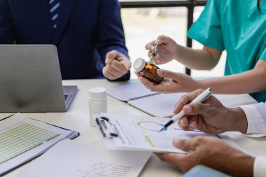 Beyaz önlüklü ve ameliyat önlüklü doktorla görüşüp hasta kayıtlarını tartışıyorlar. Dijital tablet üzerinde çalışan doktorlar, bilgisayar kullanan doktorlar tablet teknolojisi.