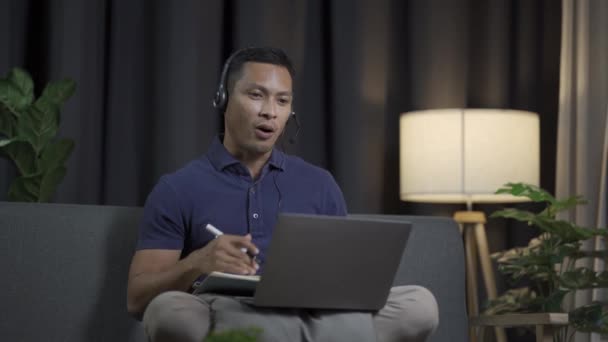 Genç Siyah Saçlı Bir Adam Kanepeye Oturur Dizüstü Bilgisayarıyla Çalışır — Stok video