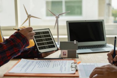 Yenilenebilir enerji kavramı güneş panelleri ve yenilenebilir enerji, bir grup mühendis, genç mimar, güneş enerjisi planlaması yapan insanlar, rüzgar türbinleri ve yeşil yenilenebilir enerji hakkında tartışır.