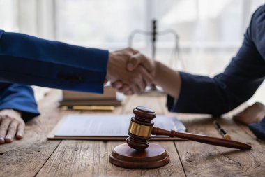 Bir avukat, bir iş ortağının zimmetine para geçirme davasında tanıklık etmeye gelen bir müşteriyle el sıkışıyor. Hukuk danışmanı, sözleşmeler ve davalar uzmanı.