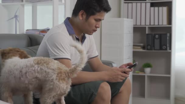 Щасливий Молодий Азіатський Чоловік Використовує Мобільний Телефон Сидячи Дивані Вітальні — стокове відео