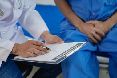 Acı çeken genç bir adam tedavi için bir doktora gitti. Doktorlar hastalarla görüşüyor ve onlara danışmanlık yapıyor. Bir doktorun ellerinde prostat hastalığı.