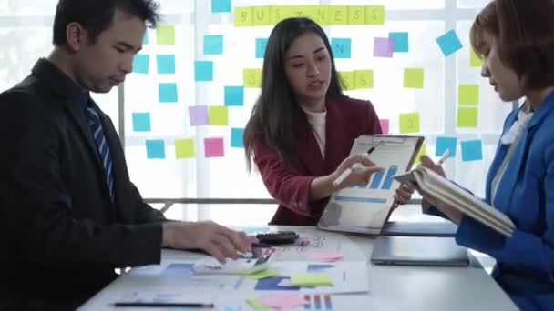 Ázsiai Üzletemberek Egy Csoportja Tárgyal Cég Értékesítési Jelentéséről Egy Megbeszélésen — Stock videók