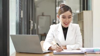 Pazarlama uzmanı, akıllı Asyalı iş kadını iş ofisinde dizüstü bilgisayar ve finansal belgeler üzerinde çalışıyor, proje yöneticisi, iş konsepti, para, 4K