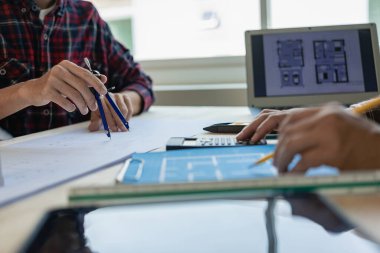 Mimarlar, yaratıcı masa mimarı tasarımı üzerinde çalışan Mimari Tasarım 'ın üzerinde materyal numunesiyle modern evin el çizimleri yapıyorlar. İnşaat Konsepti