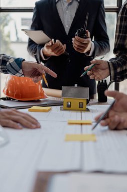 Profesyonel mimar, tasarımcı, proje tartışan meslektaşlar takımı. Bina planı tasarımı ve sunumu İnşaat mühendisi ve inşaat mühendisi model ve proje planına bakıyor.