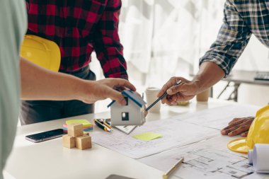 İnşaat mühendisleri, emlak sektöründeki evler veya ofis binaları için mühendislik araçları ve inşaat fikirleriyle büyük ticari binalar inşa etmek için planlar üzerinde çalışıyorlar. Yakın plan fotoğraf.