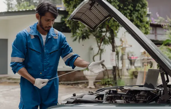 Car engine service concept Car mechanic checks engine with car repair inspection Service and maintenance Check the oil in the engine.