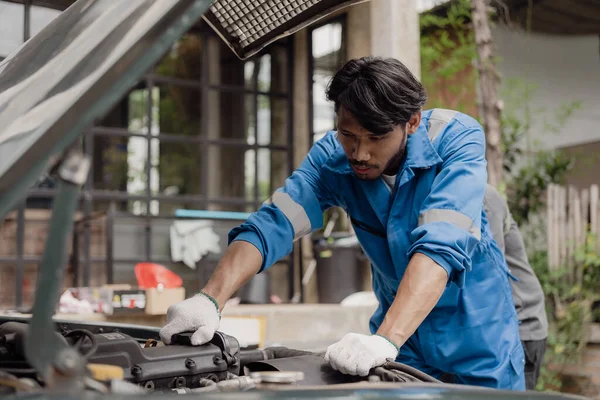 Car engine service concept Car mechanic checks engine with car repair inspection Service and maintenance Check the oil in the engine.