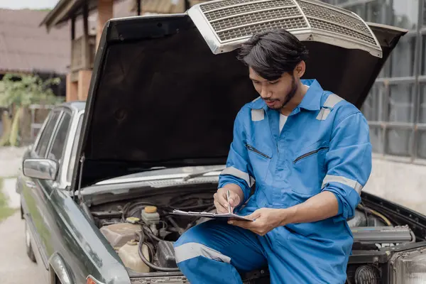 Car engine service concept Car mechanic checks engine with car repair inspection Service and maintenance Check the oil in the engine.