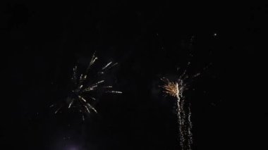 4K Real Fireworks Arkaplanı, gece gökyüzünde bokeh ışıkları, Yeni Yıl kutlamaları, yavaş çekim ile parlayan güzel altın havai fişeklerin bulanık görüntüsü.