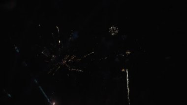 4K Real Fireworks Arkaplanı, gece gökyüzünde bokeh ışıkları, Yeni Yıl kutlamaları, yavaş çekim ile parlayan güzel altın havai fişeklerin bulanık görüntüsü.