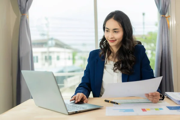 Asian businesswoman having online financial meeting with laptop Confident business executive using laptop computer having video conference, virtual meeting, financial advisor, fund research.