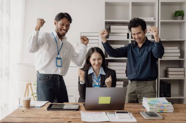 Asyalı İş Ekibi Meslektaşları, başarıyı kutlayan ve neşeli ve heyecanlı bir yaratıcılık içinde tasarım planlayan bir takım olarak çalışırlar ve başarılı bir girişim projesini alkışlamaktan mutluluk duyarlar..