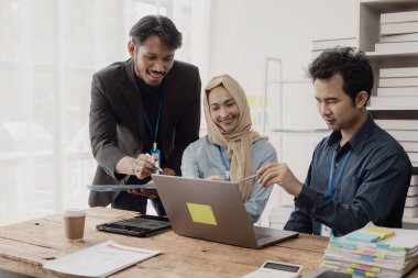 Zeki iş adamı ve İslami iş kadını masa stratejik planlamasında grup toplantılarında iş birliği yapıyor ve ofisteki meslektaşlarıyla beyin fırtınası yapıyor.