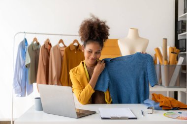 Siyahi kadın tasarımcı, bilgisayar işi, terzilik, moda, küçük işletme yaratıcılığı Afrikalı Amerikalı girişimci kız gülümseyip online siparişleri kontrol ediyor. Başarılı KOBİ iş fikri.