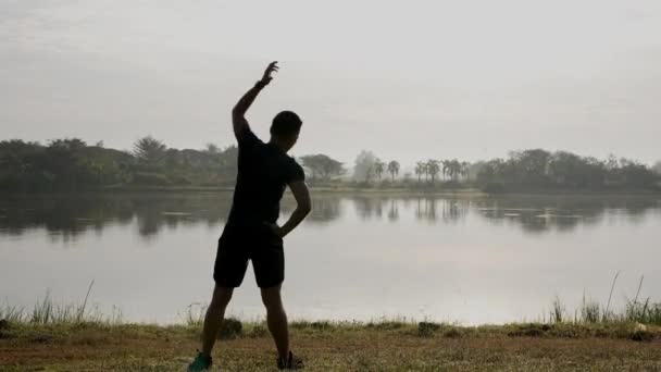 高品質の4Kヤングアジア人男性は 緑の公園の日の出中に午前ストレッチエクササイズを行っています 健康的なライフスタイルとアウトドアライフのためのアイデア — ストック動画