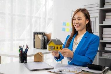 Asyalı kadın emlakçı müşteriye ev tanıtıyor, müşteriye ev ya da apartman dekorasyonunu açıklıyor, çevrimiçi ev satış danışmanı konsepti.