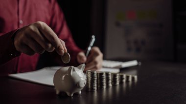Emeklilik fonlarının gelecekteki finansal hazırlıkları için planlama Geleceğin Risk Yönetimi Tasarruf hesabı İnsan eli ahşap bir masada bir kumbara tutuyor Para ve finans kavramından tasarruf