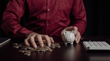 Emeklilik fonlarının gelecekteki finansal hazırlıkları için planlama Geleceğin Risk Yönetimi Tasarruf hesabı İnsan eli ahşap bir masada bir kumbara tutuyor Para ve finans kavramından tasarruf