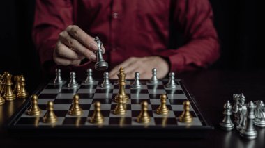 Satranç oyununu, yeni strateji planı, takım çalışması konsepti ve başarılı bir yarışmada satranç taşlarını hareket ettiren işadamlarının elleriyle kapatıyoruz. Yönetim stratejisi veya liderlik kavramı