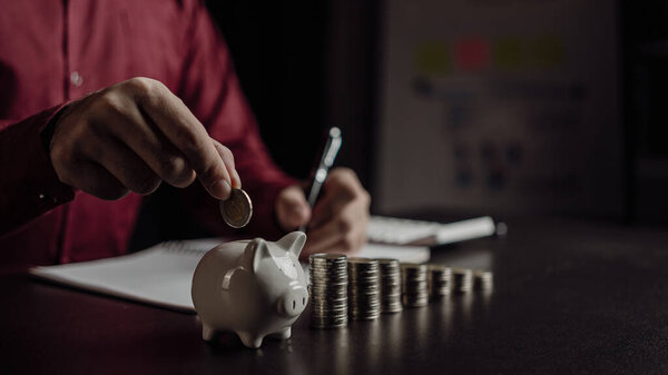 Planning savings for the future Financial preparation of retirement funds Future risk management Savings account Human hand holding a piggy bank on a wooden table Save money and finance concept