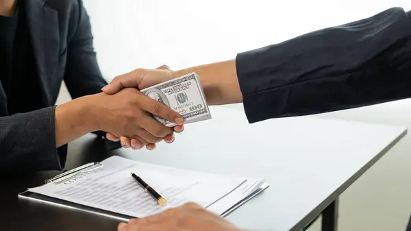 Government officials receive bribes from businessmen who have ideas about corruption and anti-bribery. Businessman's hand holding bribe to official signing contract for business project