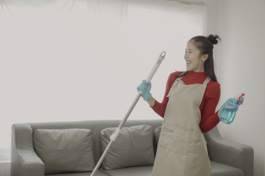 Asyalı kadın, oturma odasının ahşap zeminini temizleyen önlükle ev işi yapıyor. Temizlikçi, kirli yemek tezgahını silmekle meşgul. Ev işi ya da ev işi için.