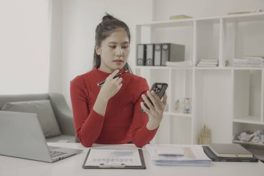 İş prensiplerini hesaplamak için finans, muhasebe, istatistik ve analitik araştırma kavramı için hesap makinesi ve dizüstü bilgisayar kullanan Asyalı kadın, ofiste muhasebe istatistikleri