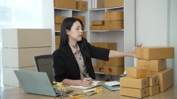 创办一个小企业 亚洲妇女中小企业业主检查网上订单 销售与盒子一起工作的产品 在家里自由职业 网上商店 中小型企业 4K视频 — 图库视频影像