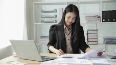 Genç Asyalı iş kadını istatistik planlama yapıyor ve elinde grafik tableti, grafik tableti ve not alıyor. Finansal istatistik başarı konsepti, 4k video