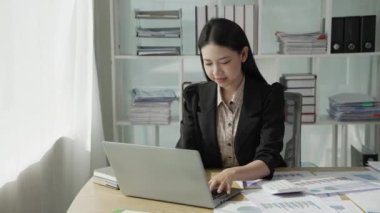 Genç Asyalı iş kadını istatistik planlama yapıyor ve elinde grafik tableti, grafik tableti ve not alıyor. Finansal istatistik başarı konsepti, 4k video