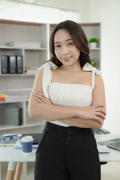 Young Asian woman working using a laptop computer, doing accounting analysis, reporting real estate investment data. Finance and tax system concepts, work at home concept