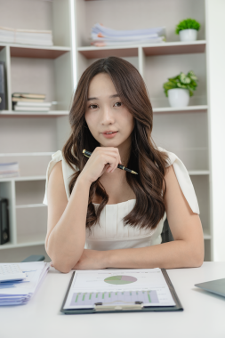 Genç Asyalı kadın dizüstü bilgisayar kullanarak çalışıyor, muhasebe analizi yapıyor, gayrimenkul yatırım verilerini bildiriyor. Maliye ve vergi sistemi kavramları, ev kavramında çalışma