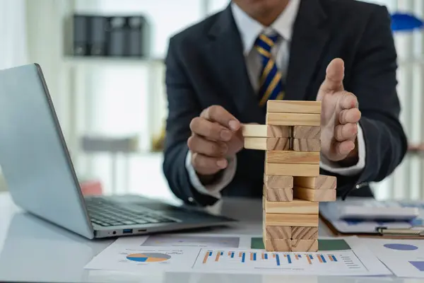 Business risk or finance concept, to prevent business risk and choose the right wooden block game or take the risk and prevent falling down, solution, insurance and strategy concept.