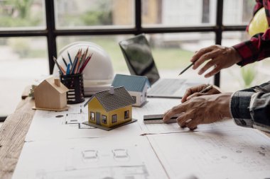 İnşaat mühendislerinden oluşan bir ekip bir bina ya da inşaat mimarisi planlıyor. Takım liderliği ya da bir tasarımcının bir toplantıda kat planı fikirlerini tartışması ya da tartışması..